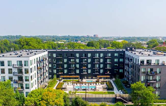 an aerial view of a large building with a pool in front of it