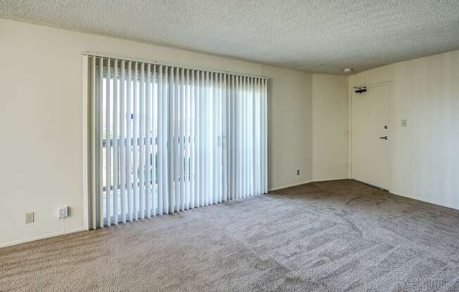 a bedroom with a large window and carpeted flooring at Terrace View Apartments, Daly City California