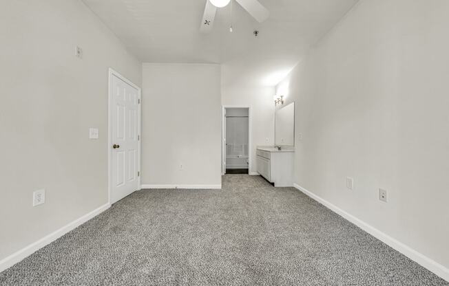 the living room of an apartment with white walls and carpet