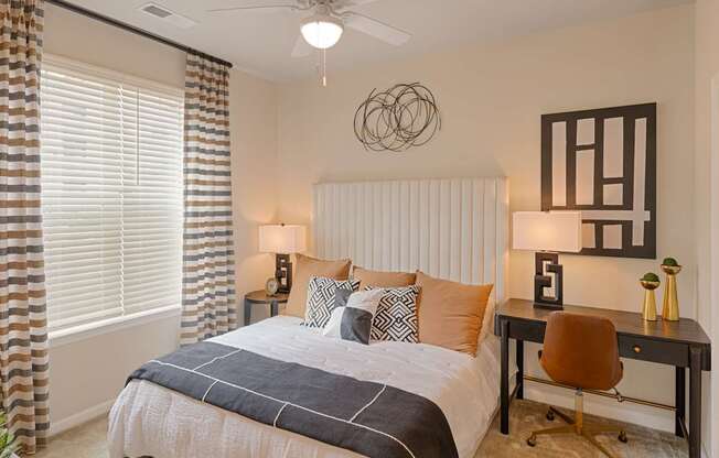 A bedroom with a bed, desk, and chair.