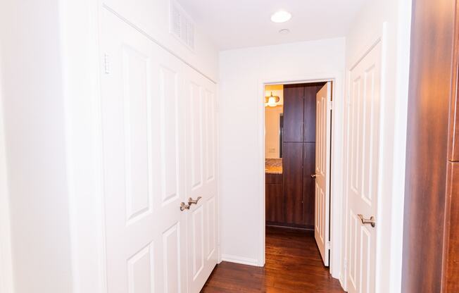 the hallway of a home with white walls and wood floors at The Vines at Riverpark, LLC, California, 93036