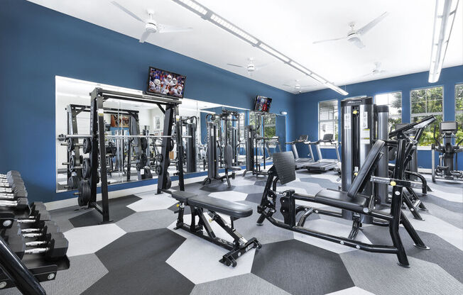a workout room with exercise equipment and a flat screen tv