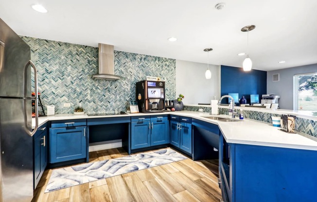 a blue and white kitchen with blue cabinets and wood floors