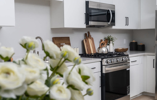 A kitchen with a black stove and white cabinets.