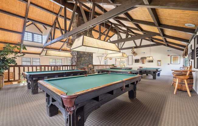 A room with a pool tables and a wooden ceiling.