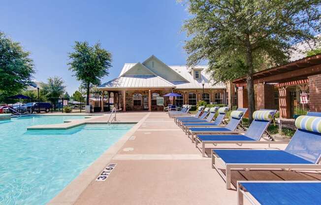 the preserve at ballantyne commons pool with chaise lounge chairs and a building