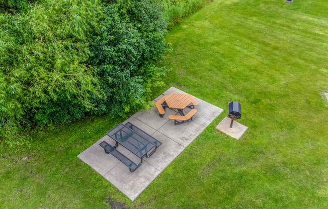 a backyard patio with a table and chairs and a fire pit at Pheasant Park Apartments, Minnesota, 55428-5401