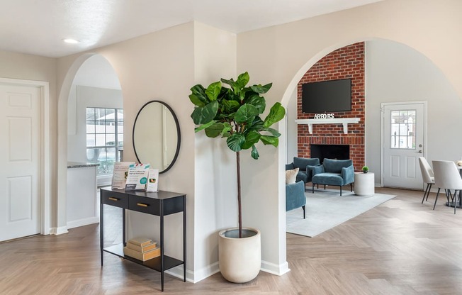 A living room with a brick fireplace and a television above it.