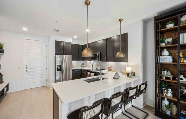 a kitchen with a white counter top and black cabinets