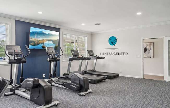 A fitness center with treadmills and elliptical machines.