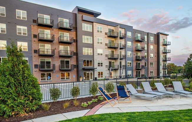 Exterior view of a modern six-story apartment complex featuring a harmonious blend of brick and metal siding. The architectural design showcases a contemporary aesthetic with clean lines and a mix of materials.