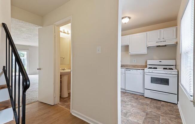 Kitchen with white appliances and tan walls at Barracks West apartments in Charlottesville, VA