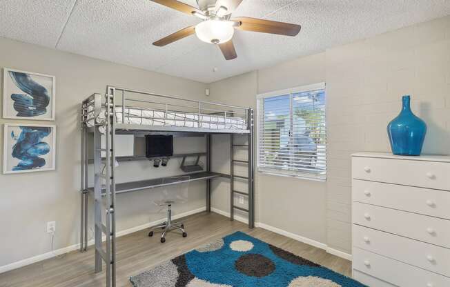 a bedroom with a bunk bed and a ceiling fan