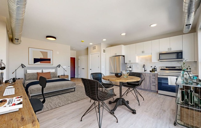 a bedroom with a bed and a table and chairs in a room