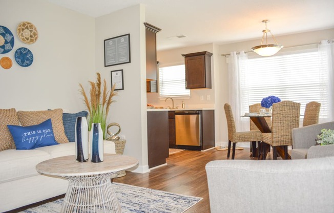 a living room with a couch and a table in front of a kitchen