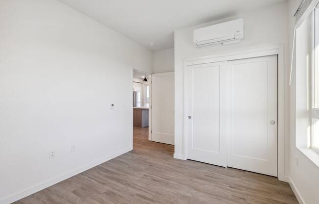 an empty living room with white walls and wood flooring