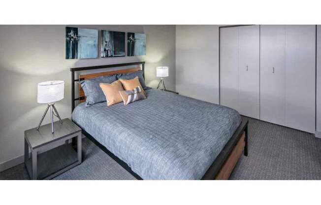 A bedroom with a bed, a nightstand, and a lamp.