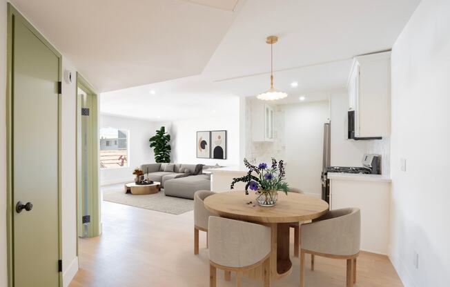 a living room and dining room with a table and chairs