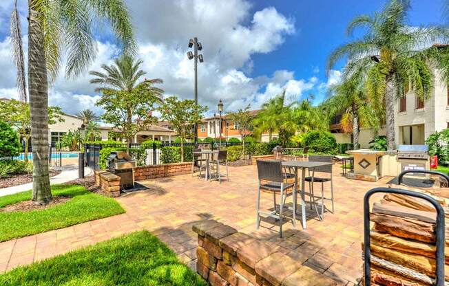 a patio with tables and chairs and a pool in the background  at Hacienda Club, Jacksonville