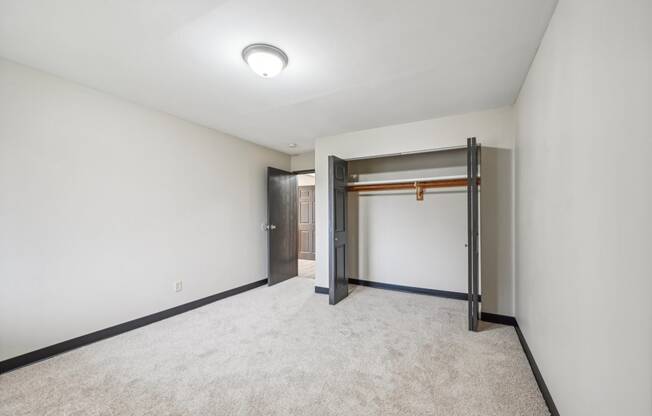 a empty room with white walls and a door to a closet