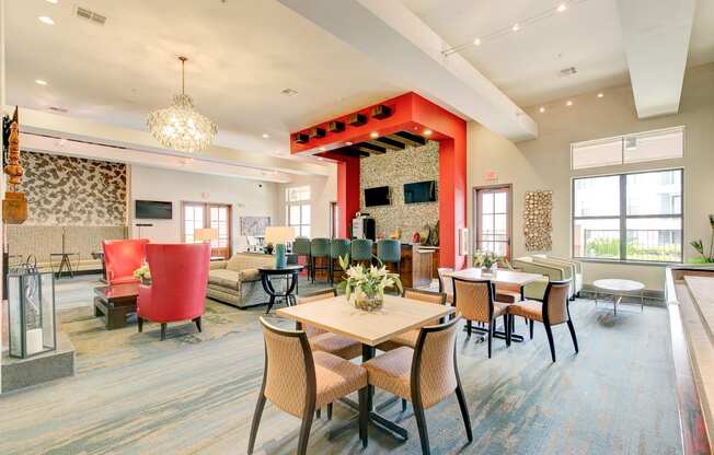 a large lobby with tables and chairs and a red pillar