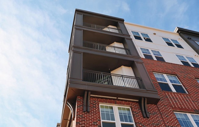 A red brick building with a balcony on the second floor.