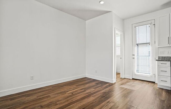 a living room with white walls and wood floors  at Aero Luxury Townhomes in Layton, Utah