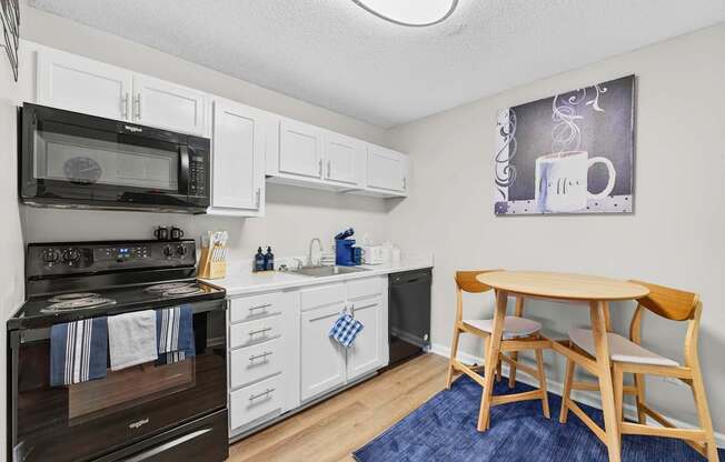 A kitchen with a black stove and white cabinets.at Lofts of Wilmington, Wilmington, NC