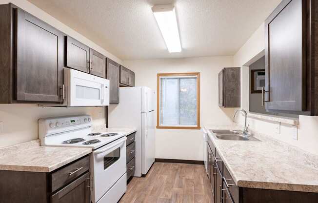 an apartment kitchen with white appliances. Fargo, ND Oxford Apartments