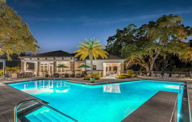 A large swimming pool in front of a building with trees around it.