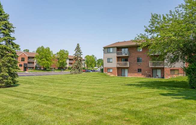 a green lawn in front of an apartment building