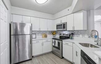 a kitchen with white cabinets and stainless steel appliances at Pembroke Pines Landings, Pembroke Pines, Florida