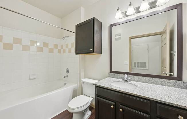 A bathroom with a white toilet, a bathtub, and a sink.
