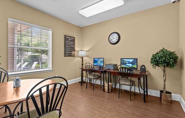 a conference room with a table and chairs and a clock on the wall