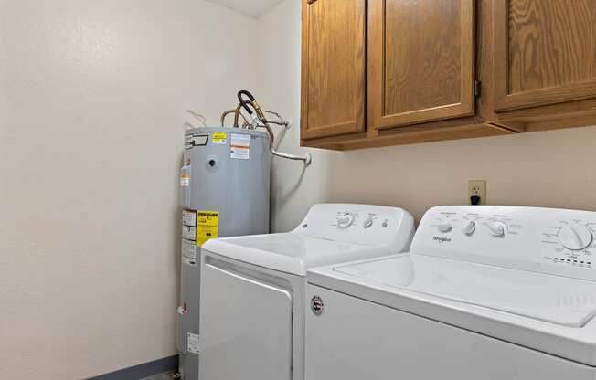 the laundry room has a washer and dryer and wood cabinets and a refrigerator
