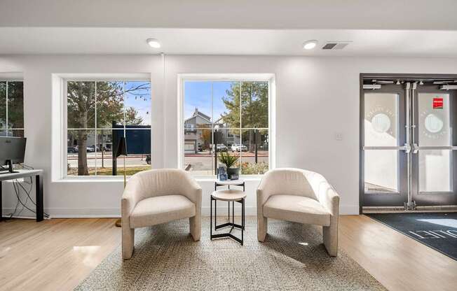 Two chairs and a table are in a room with a glass door.