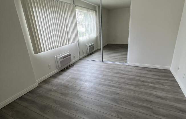 Bedroom with Hardwood Floors and Mirrored Wardrobe Closet