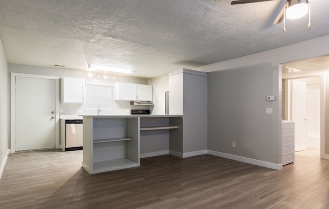 A kitchen with a white counter top and a white fridge.