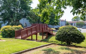 a wooden bridge in the middle of a park