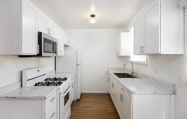 a kitchen with white cabinets and white appliances