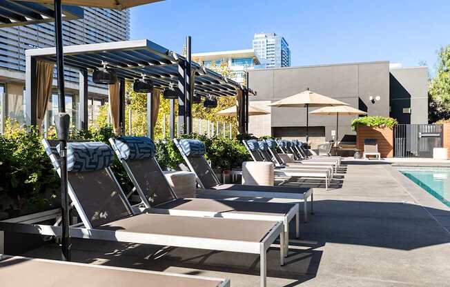 A poolside area with sun loungers and umbrellas.