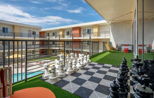 a large chess board on a balcony with a blue sky in the background