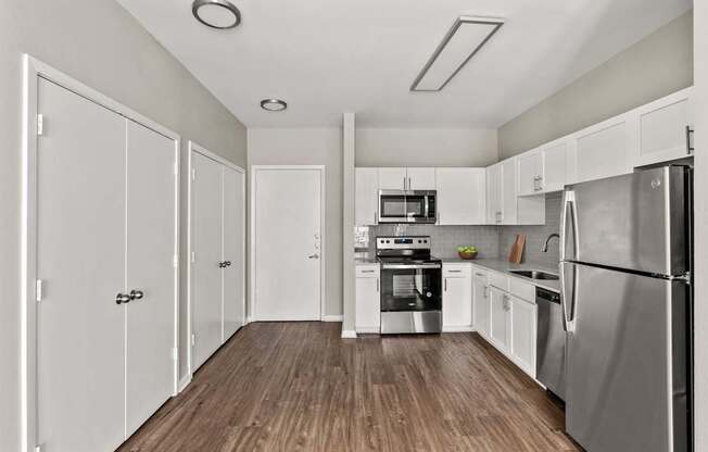 A kitchen with white cabinets and stainless steel appliances.