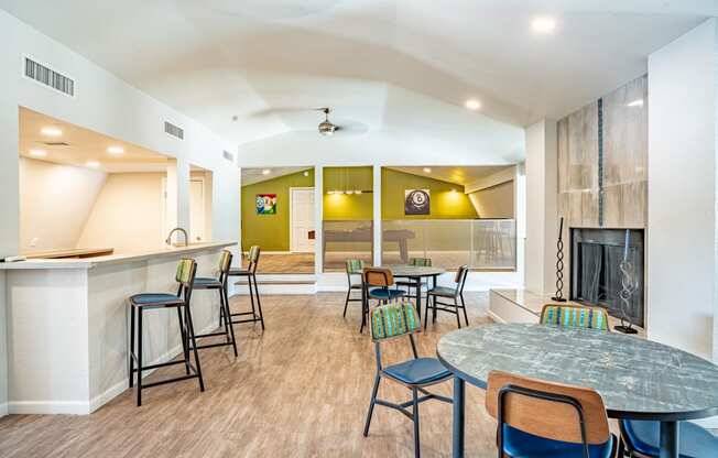 a community room with tables and chairs and a fireplace