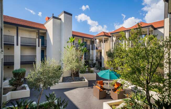 a courtyard with tables and umbrellas at the resort