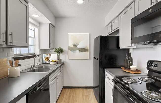 a kitchen with white cabinetry and black appliances