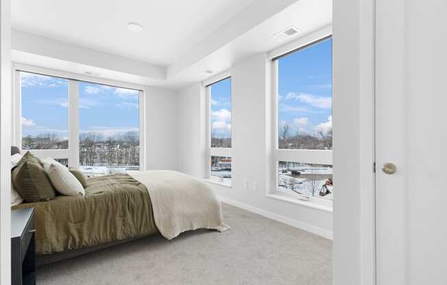 a bedroom with a bed and three windows