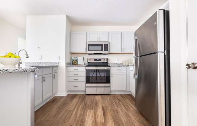 a renovated kitchen with stainless steel appliances and white cabinets