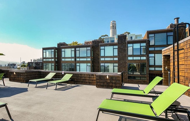 a rooftop deck with lounge chairs and a fire pit