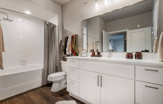 a bathroom with a large mirror and a toilet and a shower